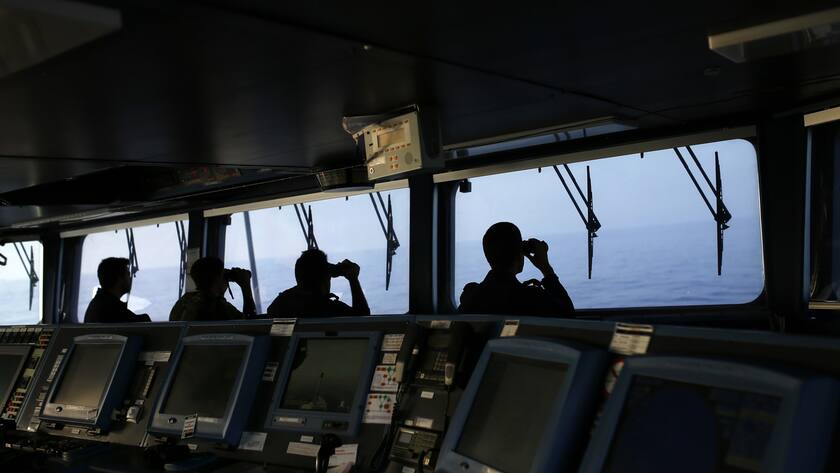 In this photo taken on Wednesday, Aug. 26, 2015, Portuguese navy ship NPR Viana do Castelo's crew members use binoculars on the bridge during a European Frontex migrant search and rescue mission in the Mediterranean Sea, off the southeastern coast of Spain. During the operation the ship searched for the bodies of a suspected migrant boat that sank few days earlier, following a report by Spanish police. (AP Photo/Francisco Seco)