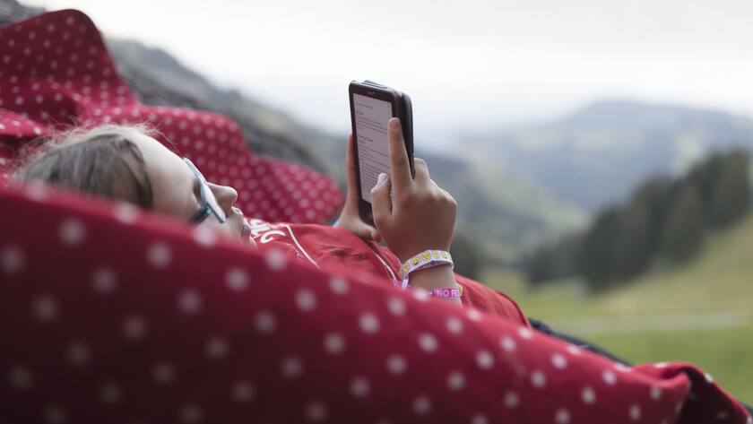 Ein Mädchen liest ein E-Book auf ihrem E-Reader auf der Rigi im Kanton Schwyz.