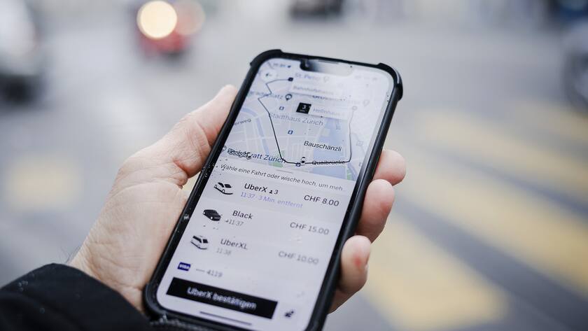 Ein Mann haelt ein Smartphone mit der Fahrdienst App Uber in Zuerich, am Donnerstag, 6. Januar 2022..Das Zuercher Sozialversicherungsgericht gelangt in mehreren Urteilen zum Schluss, dass zwischen dem Fahrdienst Uber und seinen Fahrern ein Anstellungsverhaeltnis besteht und das Unternehmen damit auch Sozialversicherungsbeitraege abliefern muss. (KEYSTONE/Michael Buholzer)