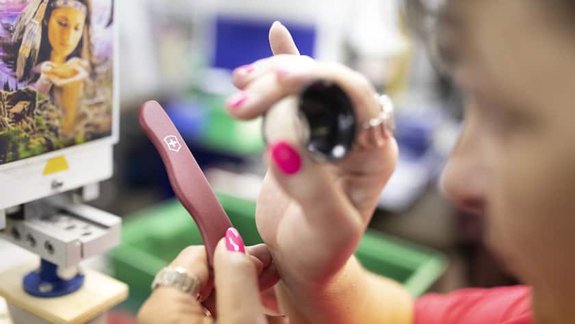 An employee checks the logo on a grip plate of a pocket knife, pictured at the Victorinox factory in Ibach, Canton of Schwyz, Switzerland, on July 10, 2018. (KEYSTONE/Gaetan Bally)
