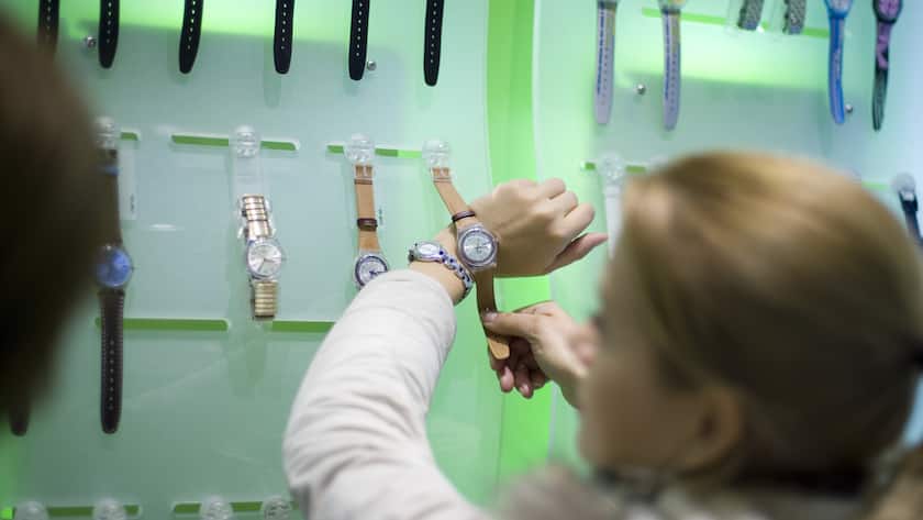 Eine Frau hält eine Uhr an ihr Handgelenk im Uhrengeschäft Swatch-Store in Zürich.