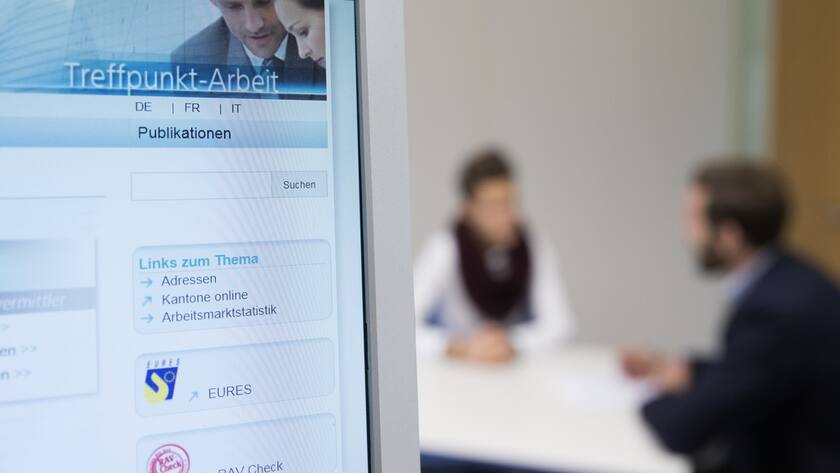 Bildschirm beim RAV-Zentrum, im Hintergrund sitzen zwei Personen an einem Tisch.