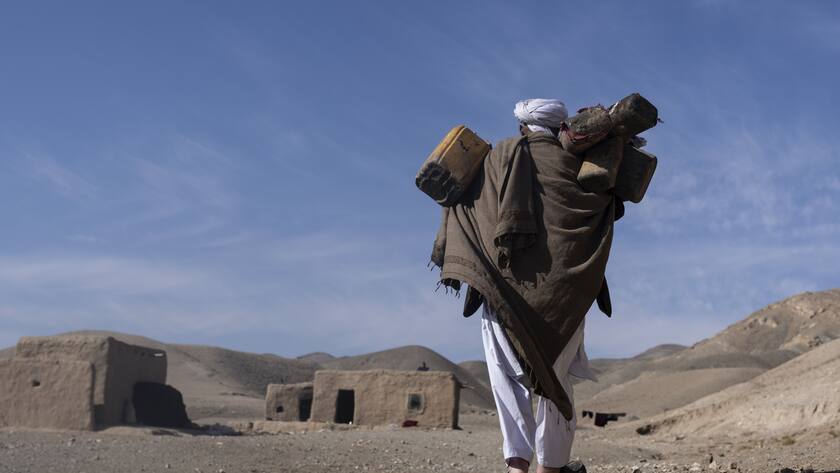 FILE - Hajji Wali Jan, 66, carries plastic containers for water on his way to his house during a drought in Kamar Kalagh village outside Herat, Afghanistan, Nov. 26, 2021. The eastern Mediterranean and Middle East are warming almost twice as fast as the global average, with temperatures projected to rise up to 5 degrees Celsius (9 degrees Fahrenheit) by the end of the century if no action is taken to reverse the trend, a new report says. (AP Photo/Petros Giannakouris, File)