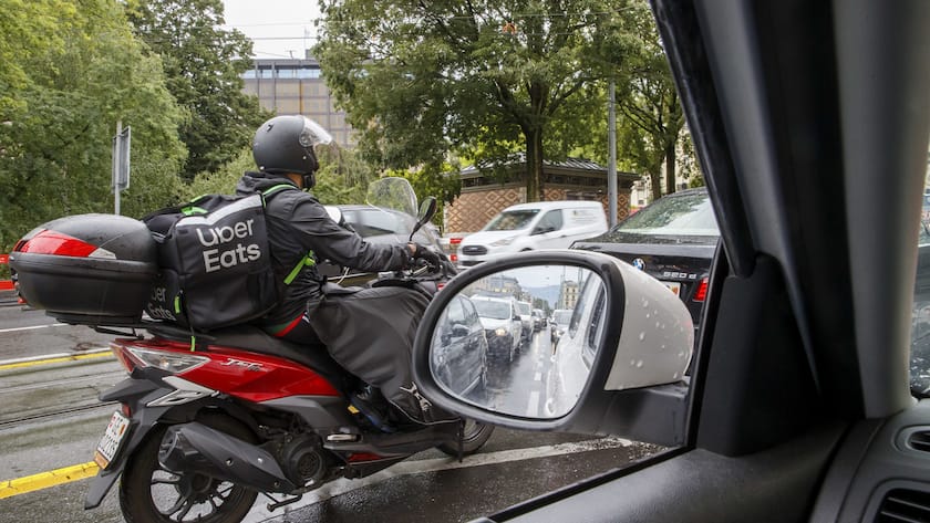 Un coursier partenaire de la societe Uber Eats roule en ville de Geneve avec un scooter pour livrer des repas a domicile, ce mercredi 7 aout 2019 a Geneve. (KEYSTONE/Salvatore Di Nolfi)