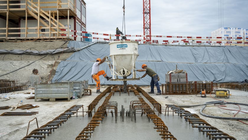 Zwei Bauarbeiter auf einer Baustelle.