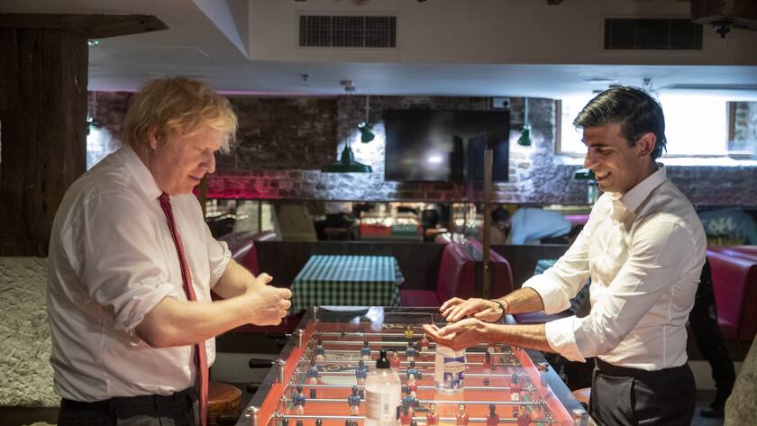 Britain's Prime Minister Boris Johnson and the Chancellor of the Exchequer Rishi Sunak, right, use hand sanitiser as they visit a restaurant in east London, Friday June 26, 2020, to see how they are getting their business ready to reopen and adapting to follow COVID-secure guidelines, as further coronavirus lockdown restrictions are lifted in England. (Heathcliff O'Malley/The Daily Telegraph via AP)
