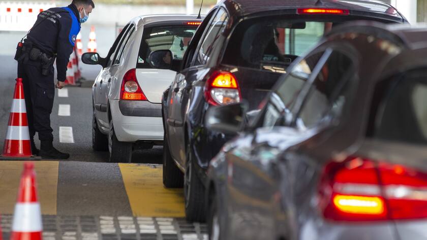 Schweizer Grenze mit Autos ein Grenzpolizist kontrolliert ein Fahrzeug.