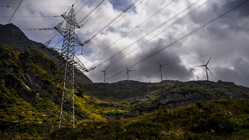 Strommasten und Windräder im Bergland