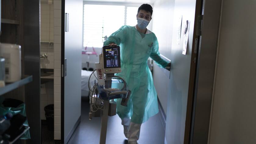 Immer mehr unter Druck: Ein Pfleger schiebt einen Blutdruck-Messer durch die Gänge des Lausanner Unispitals. Doch nicht nur das Personal leidet, auch auf die Spitäler kommen harte Zeiten zu.