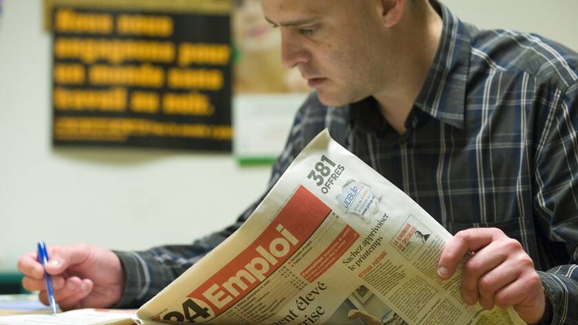 Une personne au chomage, chomeur, regarde les annonces d' emploi dans le quotidien 24 Heures dans l' Office Regional de Placement de l' Ouest Lausannois, ORP ORPOL, ce jeudi 25 mars 2010 a Renens, Vaud. (KEYSTONE/Laurent Gillieron)