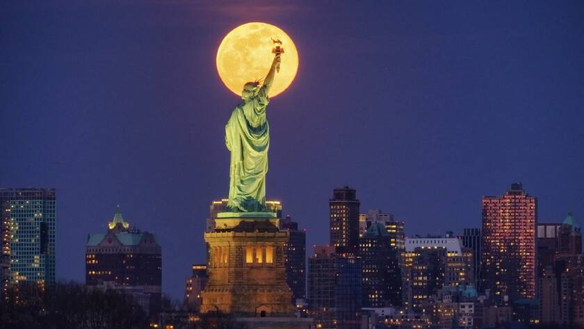 The rising full moon crosses behind the Statue of Liberty, Monday evening, March 9, 2020, in New York City. (AP Photo/J. David Ake)