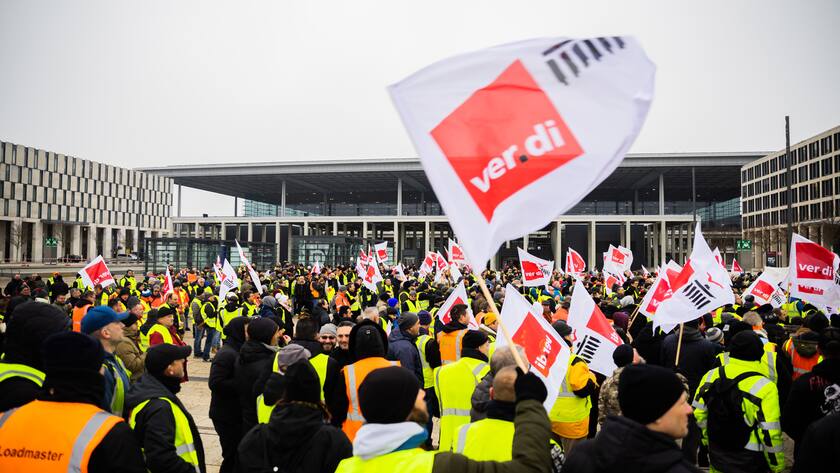 25.01.2023, Brandenburg, Schönefeld: Teilnehmer einer Demonstration zum Warnstreik am Flughafen Berlin-Brandenburg BER haben sich vor dem Flughafen auf dem Willy-Brandt-Platz versammelt. Die Gewerkschaft Verdi hat zu einem ganztägigen Warnstreik am Flughafen Berlin-Brandenburg aufgerufen. Es werden voraussichtlich keine Passagierflüge abheben oder dort landen. Foto: Christoph Soeder/dpa +++ dpa-Bildfunk +++