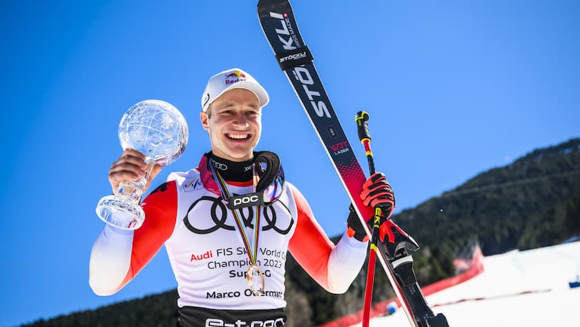 Marco Odermatt of Switzerland winner of the men's super-g overall leader crystal globe trophy celebrates with members of Swiss-ski federation in the finish area at the FIS Alpine Skiing World Cup finals in El Tarter, Andorra, Thursday, March 16, 2023. (KEYSTONE/Jean-Christophe Bott)