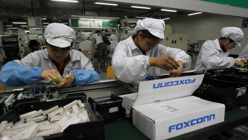 Staff members work on the production line at the Foxconn complex in the southern Chinese city of Shenzhen, Southern city in China, Wednesday, May 26, 2010. The head of the giant electronics company whose main facility in China has been battered by a string of worker suicides opened the plant's gates to scores of reporters Wednesday, hours after saying that intense media attention could make the situation worse. (AP Photo/Kin Cheung)