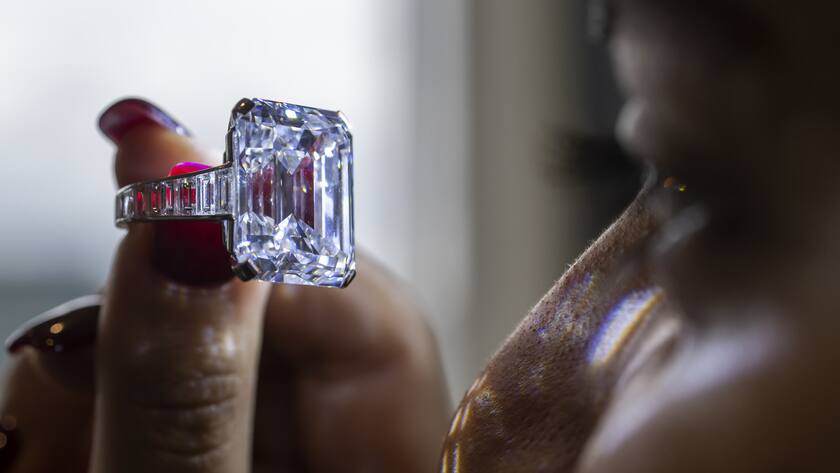 A Sotheby's employee displays a Cartier magnificent and rare sapphire and diamond, during a preview at Sotheby's in Geneva, Switzerland, on Thursday, 3 November 2022. It is estimated to sell at 2,300,000 - 3,300,000 Swiss Francs. The auction will take place in Geneva on November 09. (KEYSTONE/Martial Trezzini)