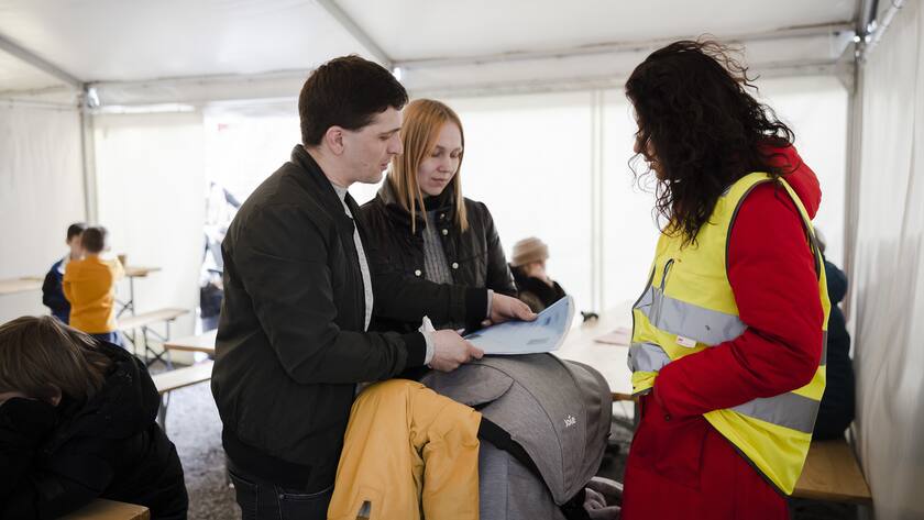 Eine Familie aus der Ukraine bespricht mit einer Mitarbeiterin die Registrierungsformulare in einem Zelt vor dem Bundesasylzentrum Zuerich, am Sonntag, 13. Maerz 2022 in Zuerich. (KEYSTONE/Michael Buholzer)