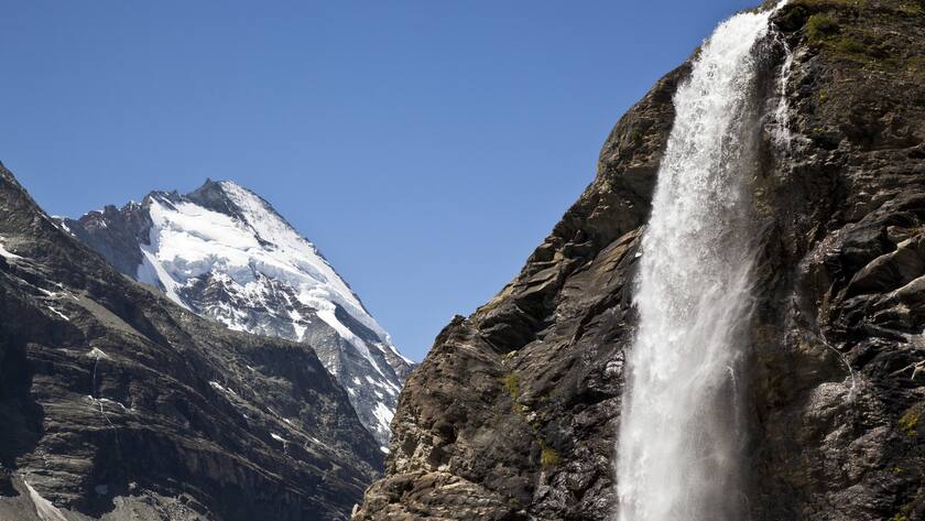 Waterfall on the way to the SAC's Schoenbiel Hut with the glacier-covered northern flank of the "Dent d'Herens" mountain above Zermatt in the canton of Valais, Switzerland, pictured on July 26, 2009. (KEYSTONE/Arno Balzarini)Wasserfall am Weg zur SAC-Schoenbielhuette mit der vergletscherten Nordflanke der "Dent d'Herens" oberhalb Zermatt im Kanton Wallis, aufgenommen am 26. Juli 2009. (KEYSTONE/Arno Balzarini)
