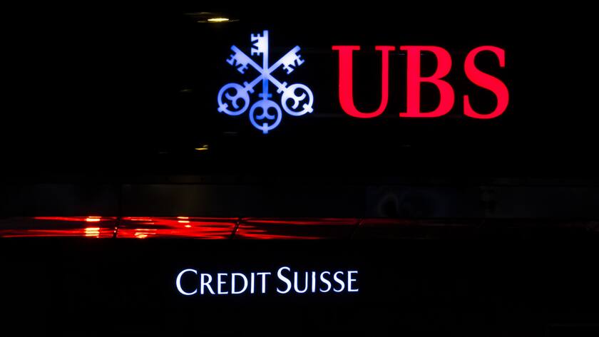 The illuminated logos of the Swiss banks Credit Suisse and UBS are seen on buildings in Zurich, Switzerland on Saturday, March 18, 2023. (KEYSTONE/Michael Buholzer).
