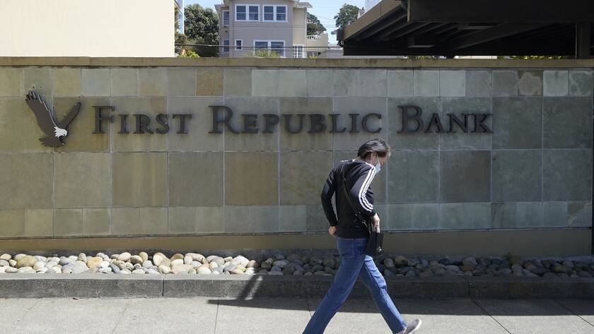 A pedestrian walks past a sign to a First Republic Bank location in San Francisco, Tuesday, April 25, 2023. First Republic Bank's stock plunged Tuesday after it said depositors withdrew more than $100 billion during last month's crisis, with fears swirling that it could be the third bank to fail after the collapse of Silicon Valley Bank and Signature Bank. (AP Photo/Jeff Chiu)