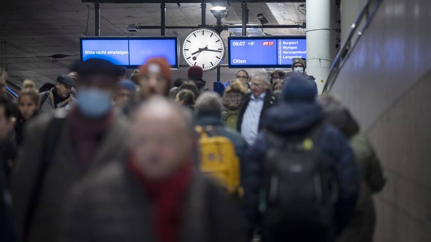 Bahnreisende gehen in die Unterfuehrung des Bahnhof Bern.