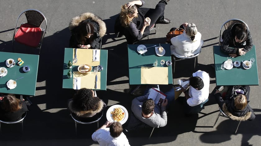 People sit outside of a restaurant on the Kornhausplatz in Bern, Switzerland, Tuesday, February 8, 2011. (KEYSTONE/Peter Klaunzer)