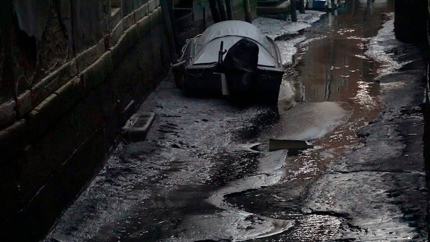 epa10480527 The muddy bottom emerges from the Rio di San Beneto in the district of San Marco, because of the exceptional low tide that has recorded 70 centimeters below sea level, in Venice, Italy, 20 February 2023. EPA/Andrea Merola