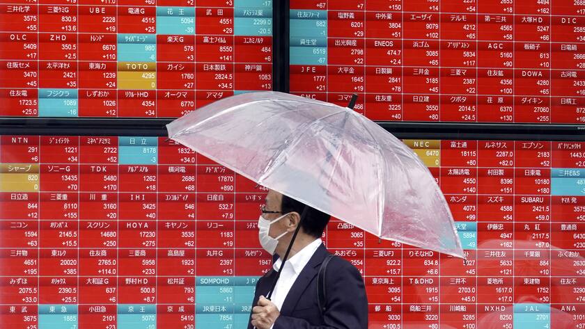 A person looks at an electronic stock board showing Japan's Nikkei 225 index at a securities firm in the rain Monday, May 29, 2023, in Tokyo. Asian shares are mostly higher after President Joe Biden and House Speaker Kevin McCarthy reached a final agreement on a deal to raise the U.S. national debt ceiling. (AP Photo/Eugene Hoshiko)