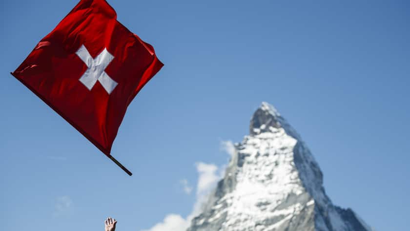 A flag thrower performs with a Swiss flag in front of the iconic Matterhorn mountain on the Gornergrat above Zermatt, Sunday, September 14, 2014. (KEYSTONE/Valentin Flauraud)