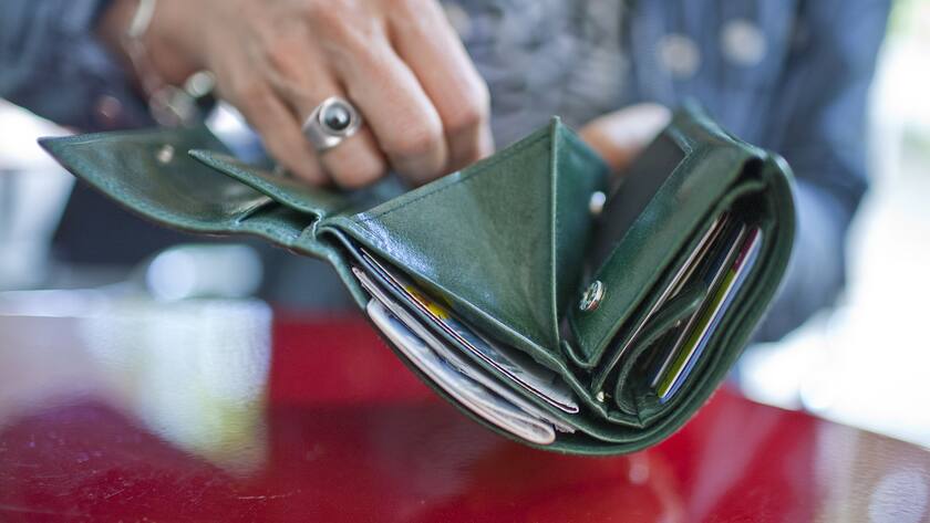 A woman holds her open purse in her hands, pictured on June 10, 2009 in Zurich, Switzerland. (KEYSTONE/Gatean Bally)Eine Frau haelt ihr geoeffnetes Portemonnaie in der Hand, aufgenommen am 10. Juni 2009 in Zuerich. (KEYSTONE/Gatean Bally)