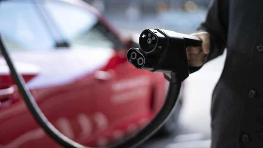 Ein Mann schliesst am Donnerstag, 10. November 2022, ein Audi e-tron-Auto an eine der vier Ladestationen des Audi charging hub in Zuerich an. Der Audi charging hub mit vier Ladestationen und einer Ladeleistung von 320 kW ermoeglicht es, ein Auto in 25 Minuten von 10% auf 80% aufzuladen. Der Audi Charging Hub besteht aus Wuerfelcontainern, die mit gebrauchten Lithium-Ionen-Batterien bestueckt sind, so dass diese Infrastruktur das Elektroauto schnell aufladen kann. (KEYSTONE/Gaetan Bally)