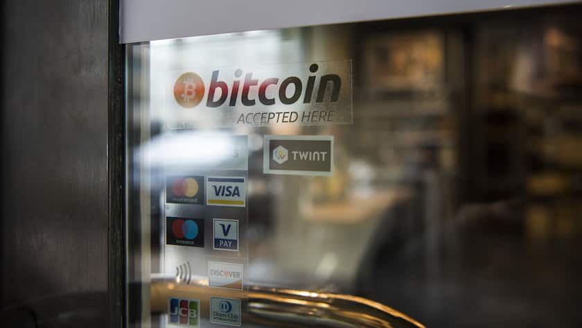 The sticker "bitcoin accepted here", affixed at the entrance door of the wine store "House of Wines" in Zug, Switzerland, indicates the payment option with Bitcoins, pictured on March 2, 2018. (KEYSTONE/Christian Beutler)Der Aufkleber "bitcoin accepted here" weist an der Eingangstuer zur Weinhandlung "House of Wines" in Zug auf die Bezahlmoeglichkeit mit Bitcoins hin, aufgenommen am 2. Maerz 2018. (KEYSTONE/Christian Beutler)