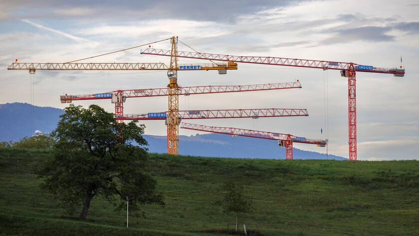 Des grues s'activent a la construction des immeubles sur le chantier du futur quartier des Grands Esserts situe sur le plateau de Vessy a Veyrier, ce mardi 12 septembre 2023 a Geneve. (KEYSTONE/Salvatore Di Nolfi)