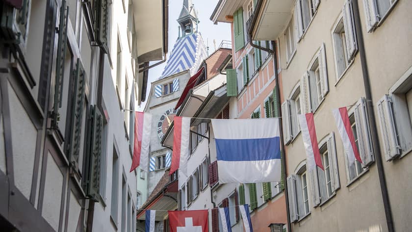 Zuger Fahnen und Schweizer Fahnen schmuecken eine Gasse in der Zuger Altstadt am Montag, 26. Juni 2023 in Zug. (KEYSTONE/Urs Flueeler).