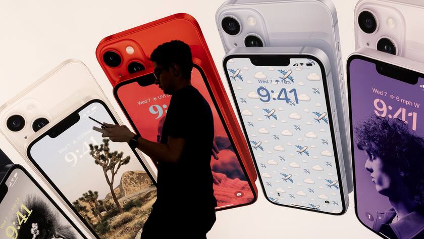 Person vor einer iPhone-14-Werbung: Das letzte Mal kam die neue Version in neuen Farben und einer verbesserten Front-Kamera.