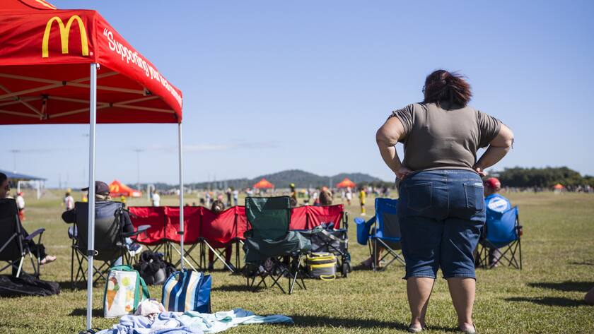 Eine Frau schaut Kindern beim Fussballspielen zu neben einem Sonneschutz mit dem Logo der Fastfood Restaurantkette Mc Donalds, am Samstag, 20. Juli 2019 in Mackay, Queensland, Australien. (KEYSTONE/Alessandro della Valle).