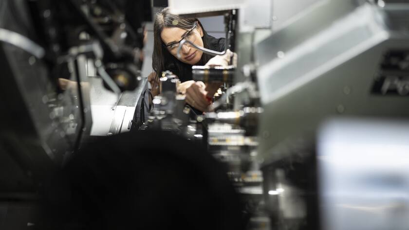 Eine Mitarbeiterin der SFS-Fabrik schraubt ein Teil von der Fraesmaschine ab, fotografiert am Montag, 9. Oktober 2023 in Heerbrugg. SFS ist ein Unternehmen fue applikationskritische Praezisionskomponenten und Baugruppen, mechanische Befestigungssysteme, Qualitaetswerkzeuge und Bewirtschaftungsloesungen. (KEYSTONE/Gaetan Bally)..