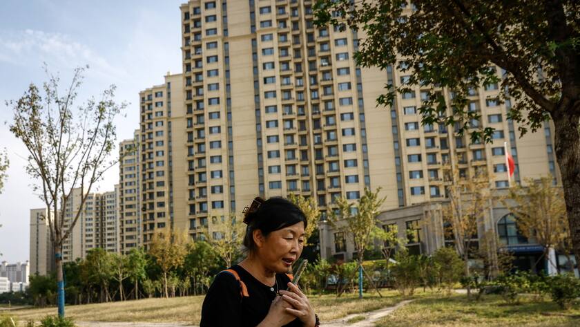 Chinesischer Baukonzern Evergrande muss liquidiert werden epa10882088 A woman uses her phone outside an Evergrande Royal Scenery housing complex in Beijing, China, 25 September 2023. China Evergrande shares went down 25 percent after it announced a delay in its debt restructuring plan. Evergrande is in the center of a real estate market crisis threatening the world's second largest economy. EPA/MARK R. CRISTINO
