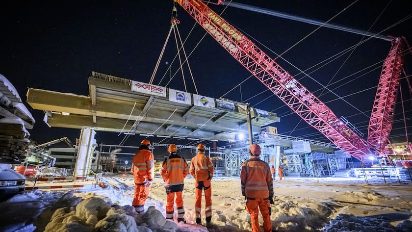 Des ouvriers observent un element metallique, long de 35 metres, large de 20 metres et pesant 200 tonnes, en train d'etre pose au-dessus des voies du chemin de fer sur le chantier de remplacement du Grand-Pont a La Chaux-de-Fonds, ce jeudi 7 decembre 2023. (KEYSTONE/Gabriel Monnet)