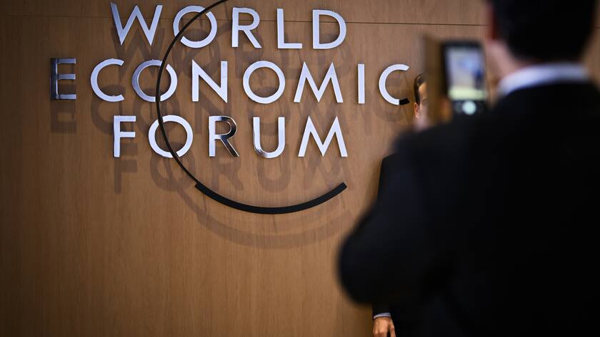 A participant has a picture taken in front of the WEF logo on the closing day of the 53rd annual meeting of the World Economic Forum, WEF, in Davos, Switzerland, Friday, January 20, 2023. The meeting brings together entrepreneurs, scientists, corporate and political leaders in Davos under the topic "Cooperation in a Fragmented World" from 16 to 20 January. (KEYSTONE/Gian Ehrenzeller)
