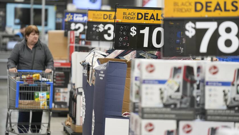 FILE - Signs advertise Black Friday deals at a Walmart in Secaucus, N.J., Nov. 22, 2022. According to the December Associated Press-NORC Center for Public Affairs Research poll, Republicans and Democrats have distinct views of what's most important for the government to address amid high inflation. More Republicans name gas and food prices, energy and immigration; more Democrats focus on health care, climate change and poverty. (AP Photo/Seth Wenig, File)