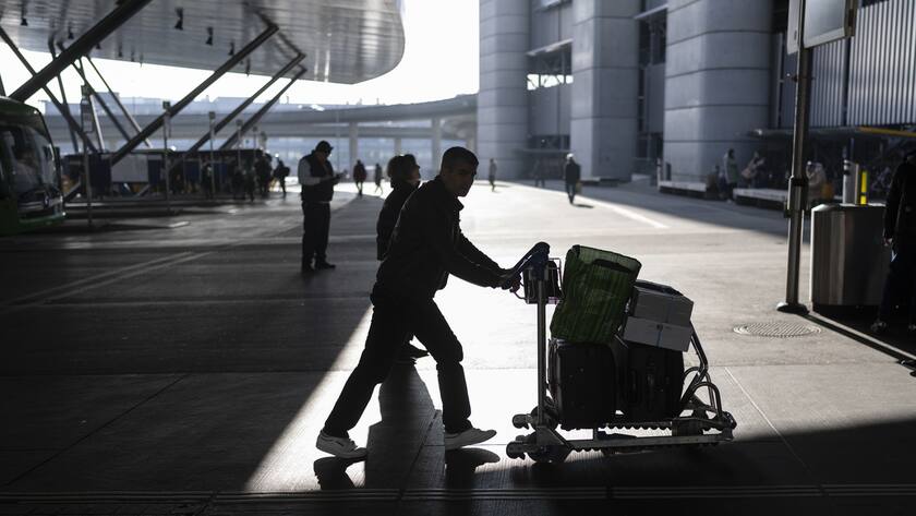 Eine Person schiebt einen Wagen mit Gepaeck in Richtung Check-in am Sonntag, 14. Januar 2024 am Flughafen Zuerich in Kloten. (KEYSTONE/Gaetan Bally)