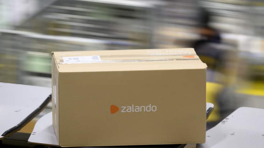 Un paquet "Zalando" est transporte sur un tapis roulant au centre colis de La Poste ce jeudi 15 decembre 2022 a Daillens, Vaud. Pendant les jours de pointe avant Noel, le volume depasse souvent les 230 000 colis. La capacite de tri maximale s'eleve a 19 000 colis par heure. En 2021, la Poste a trie au total 45,2 millions de colis a Daillens. (KEYSTONE/Laurent Gillieron)