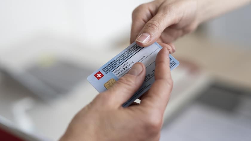 Eine Patientin uebergibt ihre Krankenkassenkarte, aufgenommen in der PhysioPraxis Uster am Montag, 22. April 2024 in Uster. (KEYSTONE/Ennio Leanza)