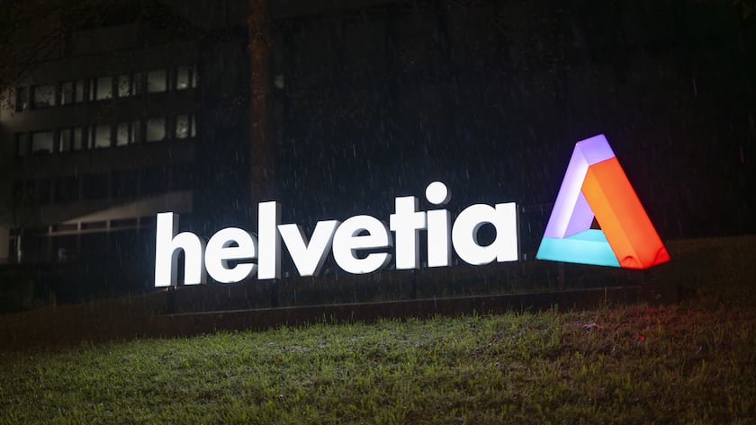 Das Logo der Helvetia Versicherungen leuchtet im Dunkeln, aufgenommen am Freitag, 23. April 2025, in St. Gallen. (KEYSTONE/Gian Ehrenzeller)