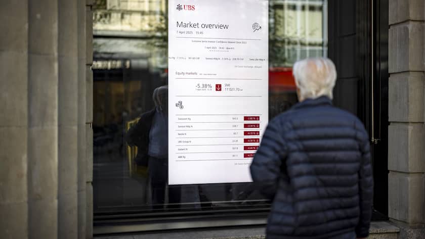 A man looks at a market board at the headquarters of the Swiss bank UBS in Zurich, Switzerland, on Monday, April 7, 2025 in Zurich, Switzerland. (KEYSTONE/Michael Buholzer)..