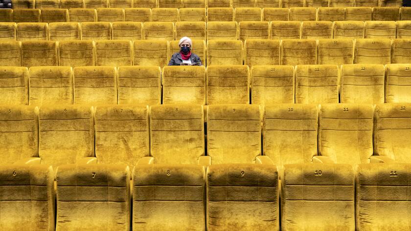 Eine Besucherin sitzt in einem Kinosaal im Kino Kosmos und wartet auf den Start eines Films, am Freitag, 6. November 2020, in Zuerich. Die Pandemie und die Schutzmassnahmen gegen das Coronavirus treffen auch die Kinos hart: Es sind nur 50 Personen pro Kinosaal erlaubt, es muss immer ein Sitz Abstand eingehalten werden und auch waehrend der Vorstellung eine Maske getragen werden. (KEYSTONE/Alexandra Wey)