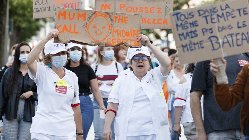 Des personnes manifestent lors d'une journee de mobilisation du personnel de la sante ce mercredi, 23 juin 2021 au CHUV (Centre hospitalier universitaire vaudois) a Lausanne. Les salaries du CHUV se mobilisent pour obtenir des renforts des effectifs, une prime Covid juste et des ameliorations des salaires. (KEYSTONE/Cyril Zingaro)