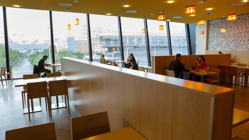 Customers with social distancing eat into the Migros restaurant during the global reopening of the Centre Balexert, in Geneva, Switzerland, Monday, May 11, 2020. In Switzerland from today, the Swiss authorities lifted second part of the lockdown. Classroom teaching at primary and lower secondary schools will again be permitted