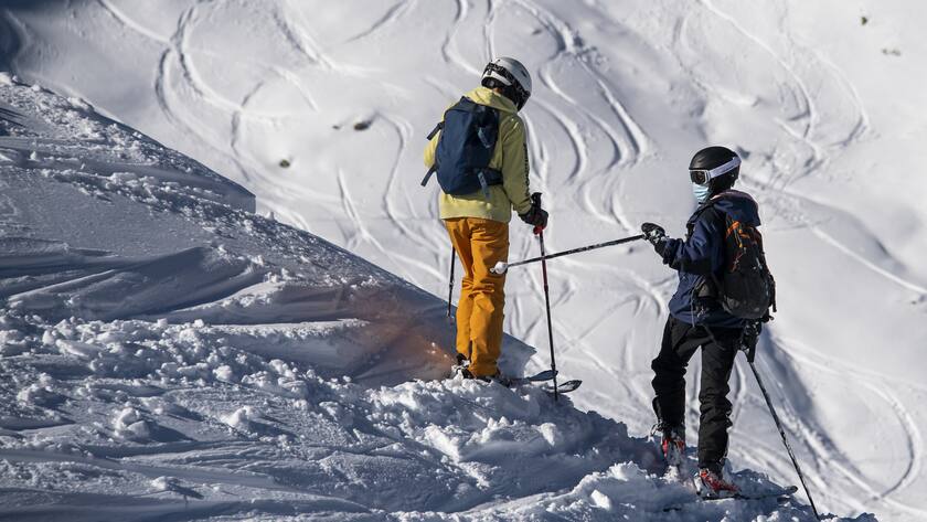 Skiers wearing face masks ski down the slope on the opening day of the Verbier ski area in the Swiss Alps during the coronavirus disease (COVID-19) outbreak, in Verbier, Switzerland, Friday, October 30, 2020. (KEYSTONE/Jean-Christophe Bott) Des skieur avec des masques de protection profitent de l'ouverture du domaine skiable de Verbier pour descendre a ski la piste du Lac des Vaux pendant la crise du Coronavirus (Covid-19) le vendredi 30 octobre 2020 a Verbier. (KEYSTONE/Jean-Christophe Bott)