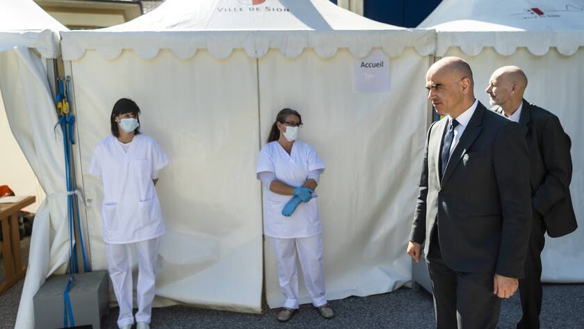 Le Conseiller federal Alain Berset, gauche, arrive au CIA le centre investigation ambulatoire de Sion en compagnie de Daniel Koch, droite, responsable de la division des maladies transmissibles de l'Office federal de la sante publique (OFSP), lors d'une visite en Valais pendant la pandemie de Coronavirus (Covid-19) le lundi 6 avril 2020 a Sion. (KEYSTONE/Jean-Christophe Bott)
